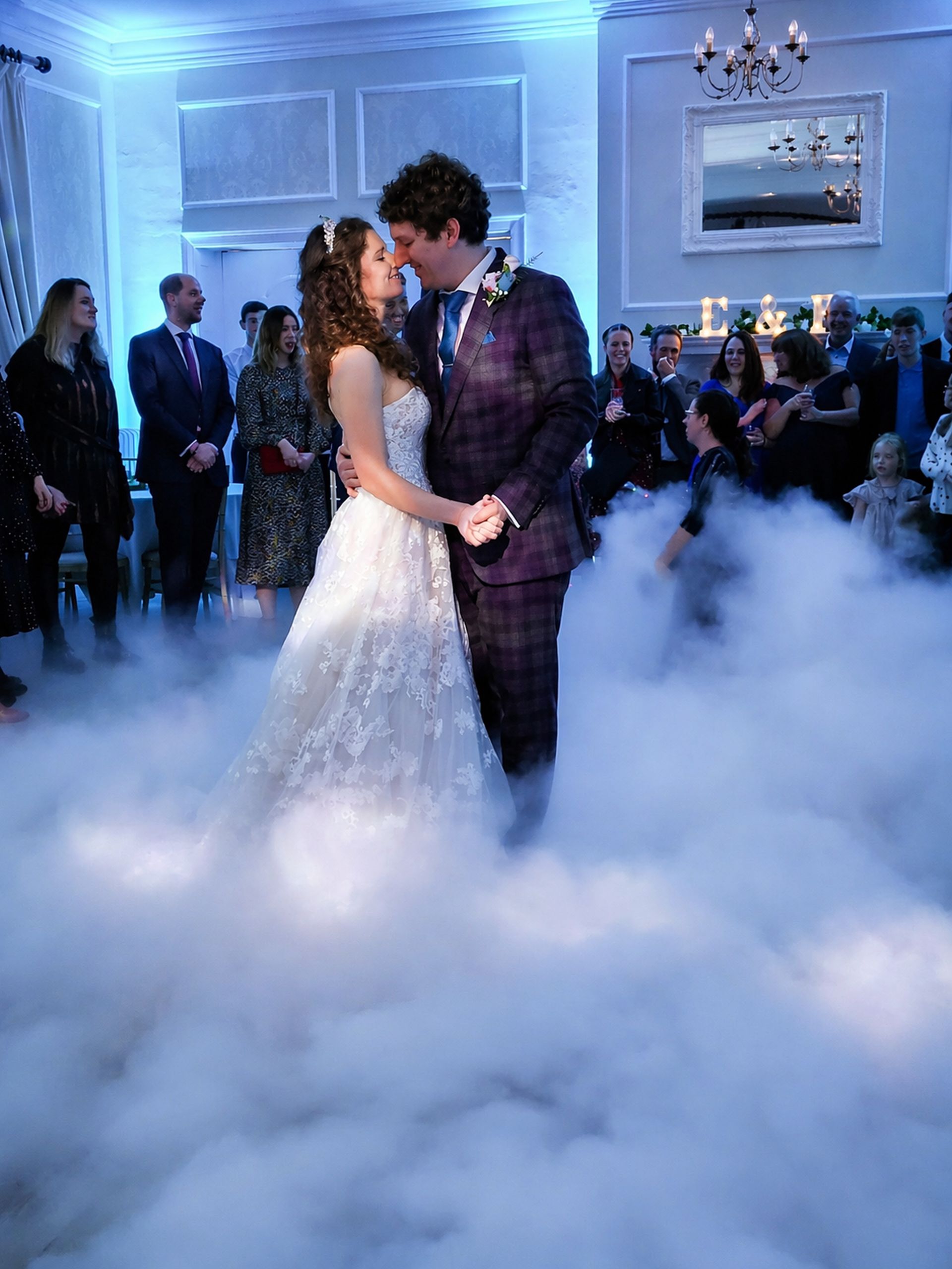 Bride and groom sharing their first dance surrounded by low cloud